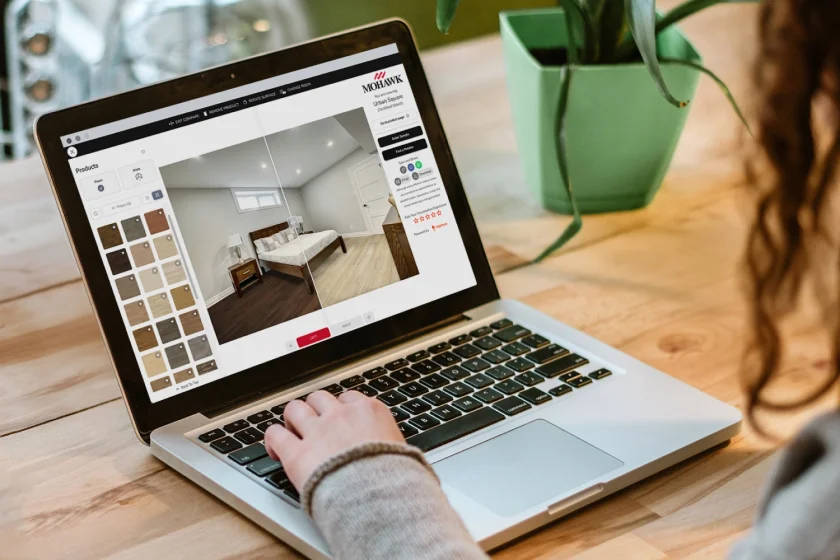 A laptop on a kitchen table showing a room visualizer with flooring samples.