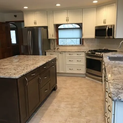 Stone look tile flooring across a kitchen with a large island and granite counters.