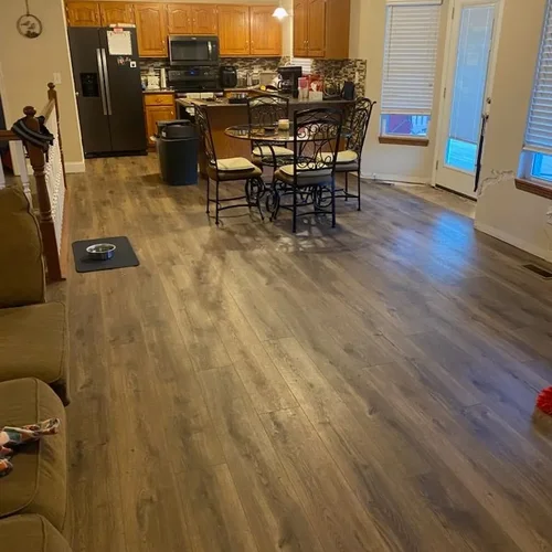 Grey brown wood look plank flooring running through a kitchen and dining space.