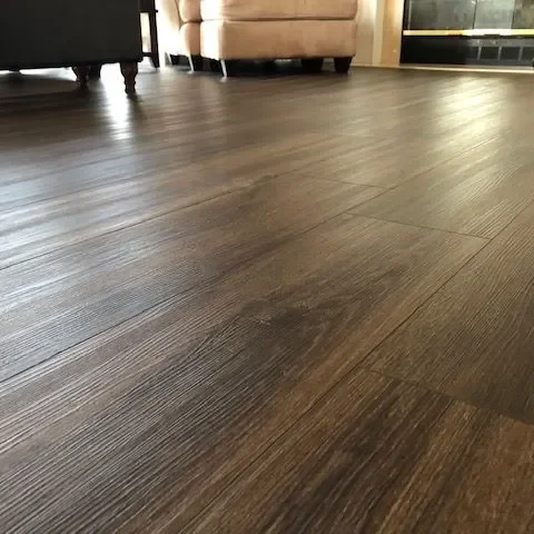 Close view along a dark wood look plank floor showing the plank texture and joints.